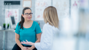 Médica explicando ao paciente como funciona o tratamento com cannabis medicinal durante uma consulta.